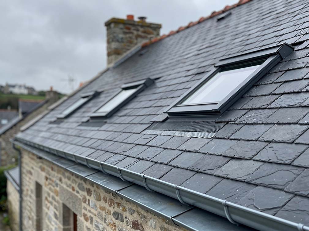 Couvreur professionnel travaillant sur une toiture en ardoise à Quimper